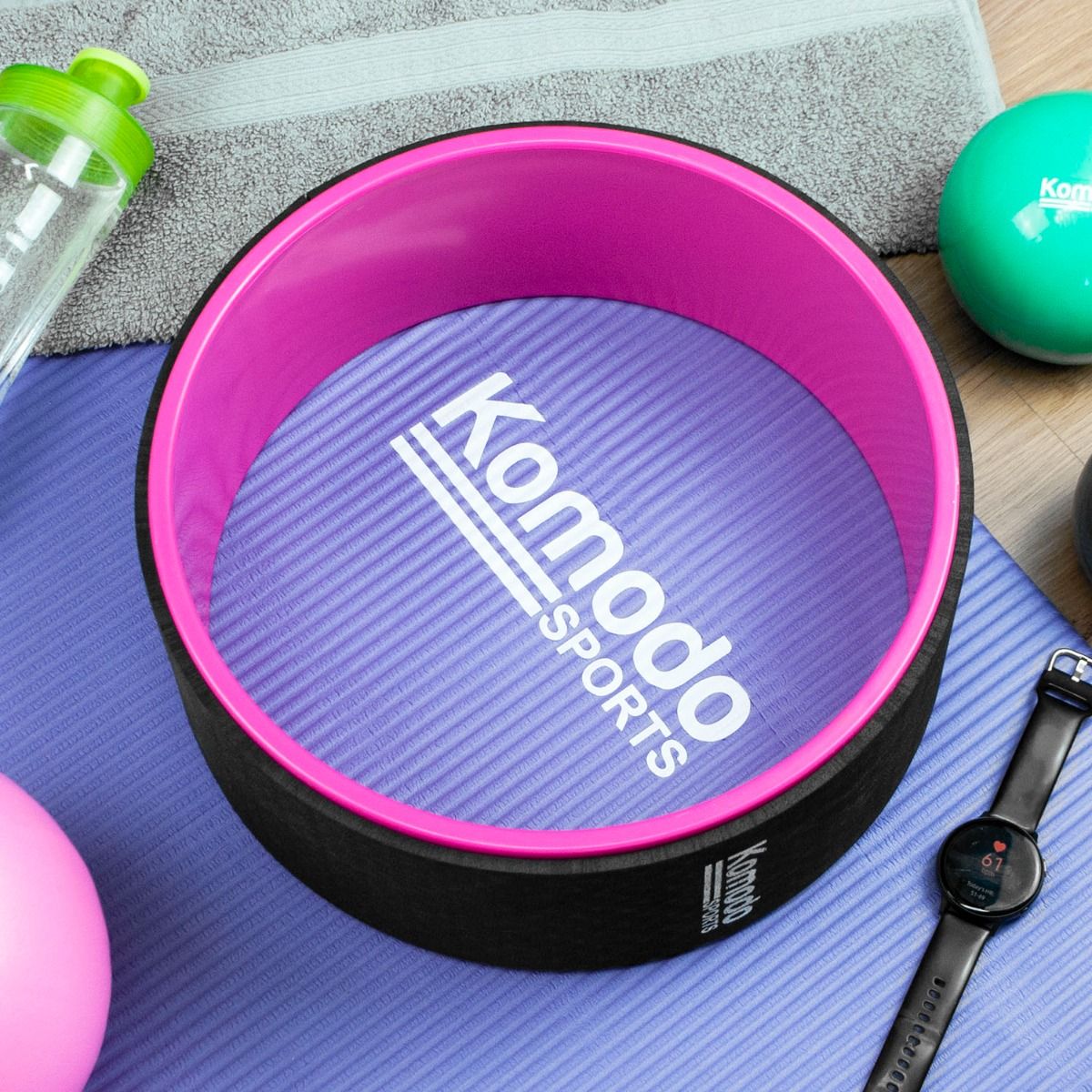 A pink Komodo Sports Yoga Wheel