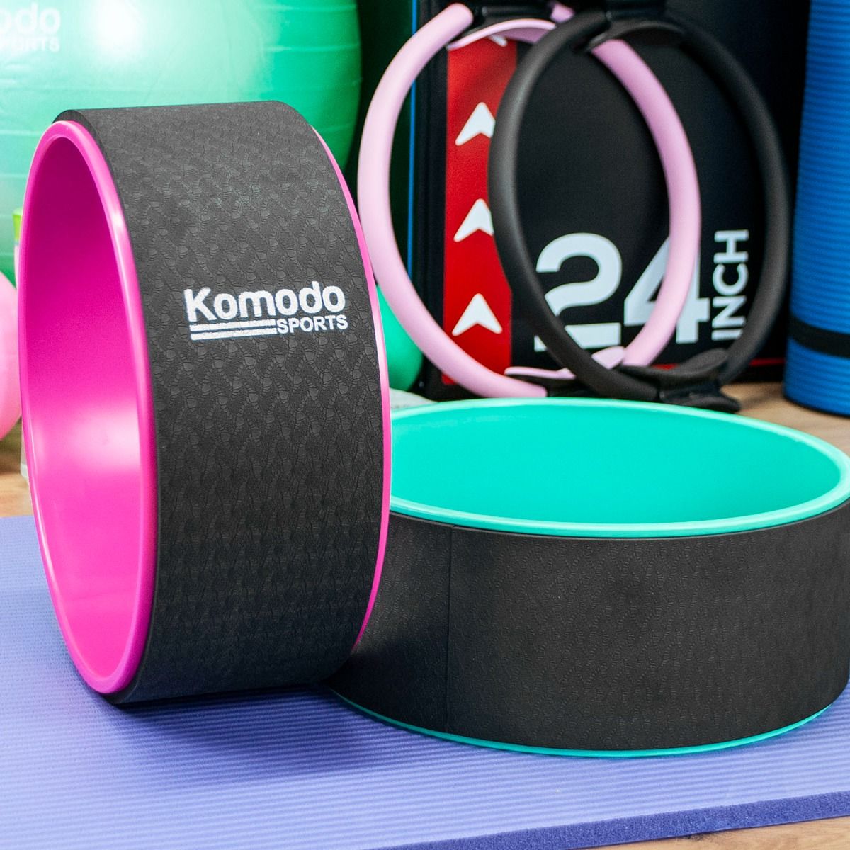 A pink & green Komodo Sports Yoga Wheel